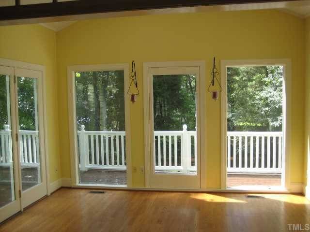 8308 Harps Mill Road Raleigh, NC 27615 - Photo 6 of 12 Spacious sun room just off the kitchen, done in a cheerful yellow with gleaming hardwood floors. Sun Room