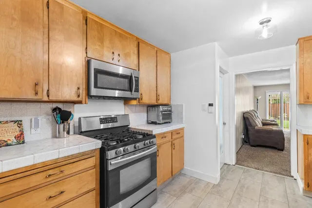 a kitchen with stainless steel appliances granite countertop a stove a sink and a microwave