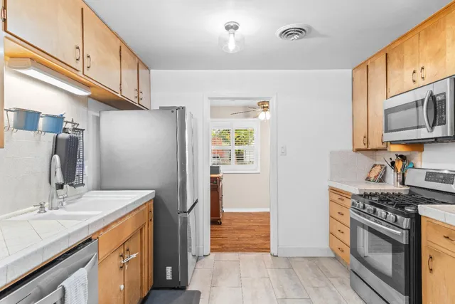 a kitchen with stainless steel appliances granite countertop a sink stove and refrigerator