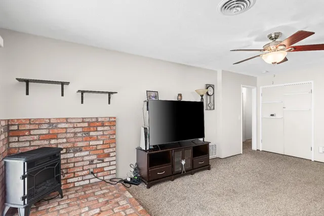a living room with flat screen tv and a fireplace