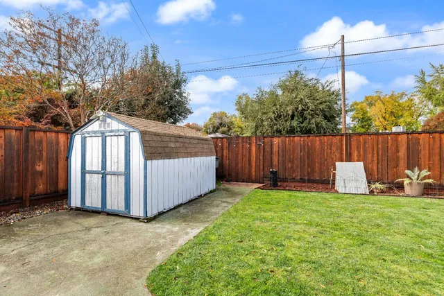 a view of a backyard with a garden and entertaining space