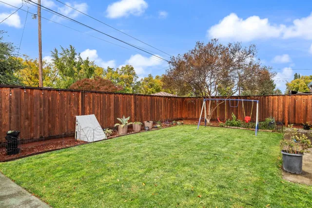 a view of a house with backyard and sitting area