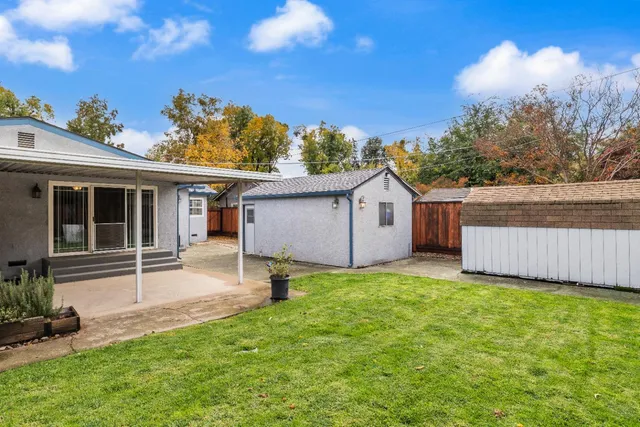 a backyard of a house with table and chairs