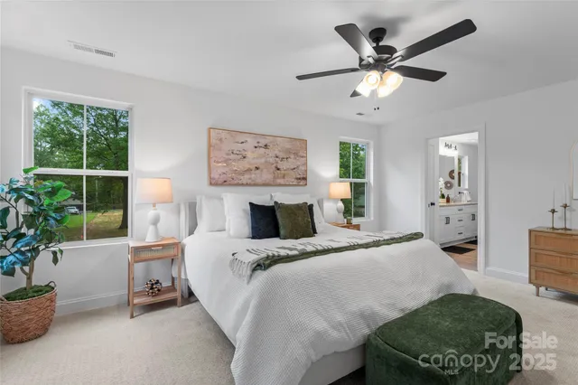 a spacious bedroom with a bed a couch and a potted plant