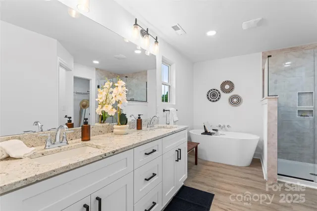 a spacious bathroom with a granite countertop sink mirror and bathtub