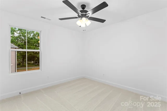 an empty room with a window and a fan
