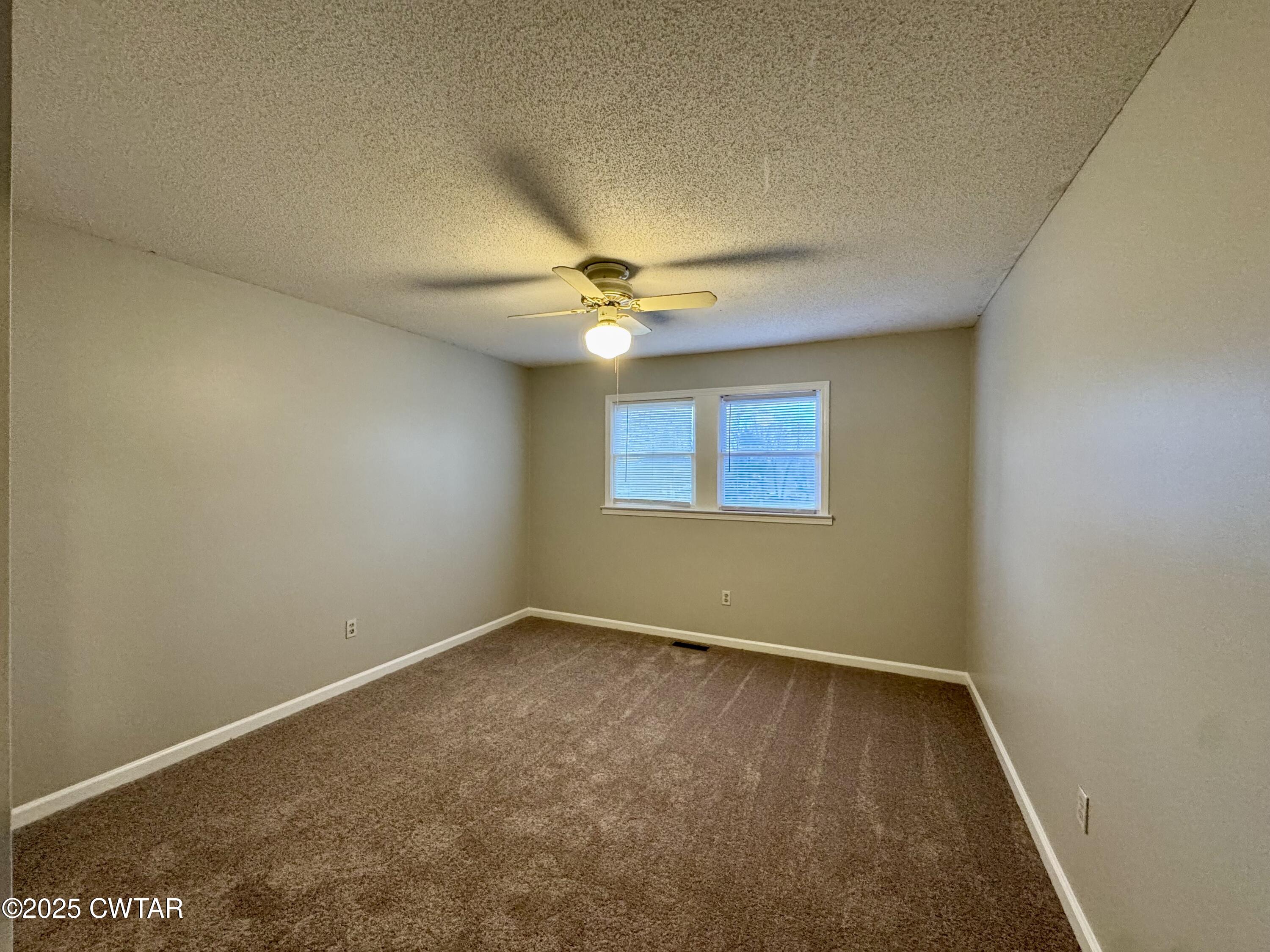 212 Fox Run Drive Jackson, TN 38305 - Photo 16 of 32 an empty room with a ceiling fan and window