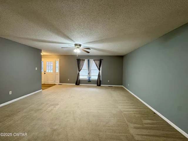 an empty room with windows and cabinet