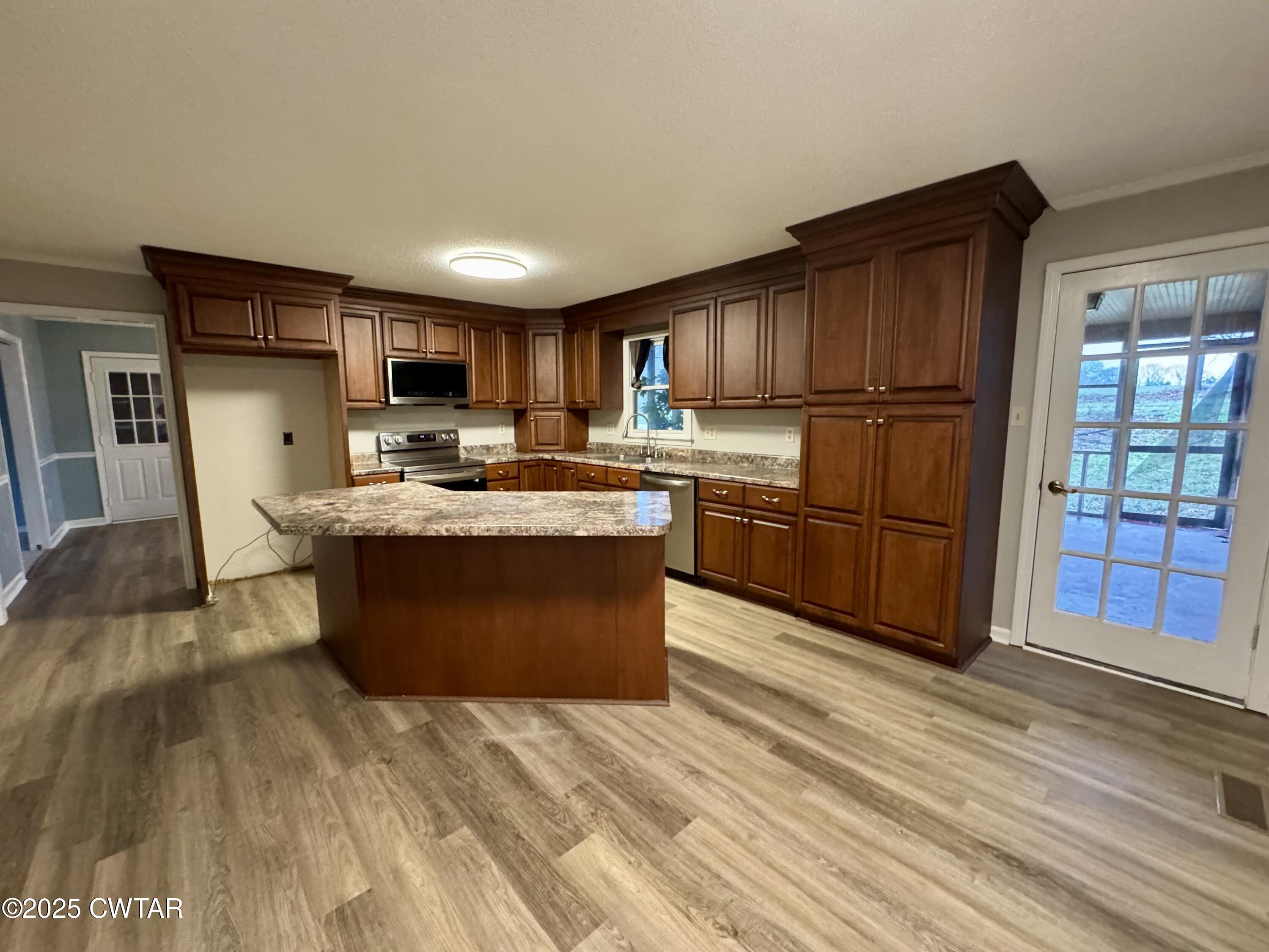212 Fox Run Drive Jackson, TN 38305 - Photo 8 of 32 a kitchen with stainless steel appliances granite countertop a stove top oven a sink dishwasher a refrigerator and a cabinets with wooden floor