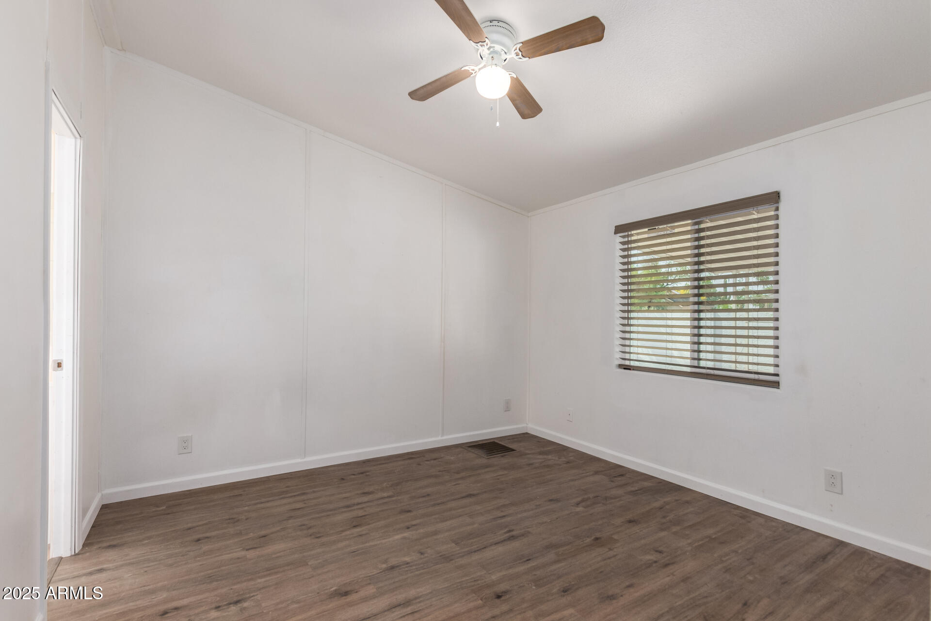 2388 South Vista Road Apache Junction, AZ 85119 - Photo 15 of 34 an empty room with wooden floor ceiling fan and windows