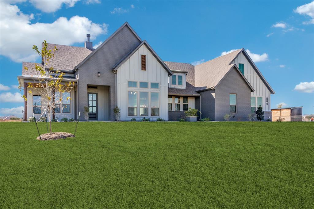 a view of a house with a yard and pathway
