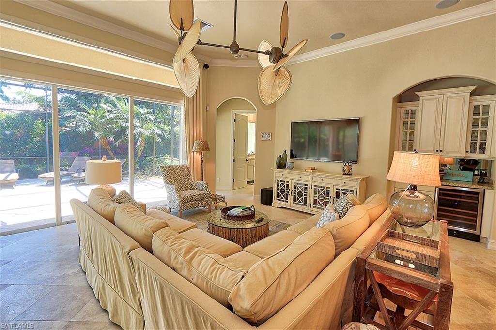 1824 Crayton Road Naples, FL 34102 - Photo 11 of 37 a living room with furniture a flat screen tv and a floor to ceiling window