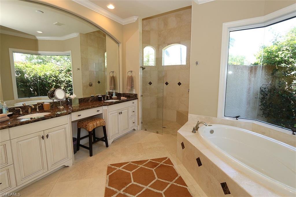 1824 Crayton Road Naples, FL 34102 - Photo 19 of 37 a spacious bathroom with a tub sink and mirror