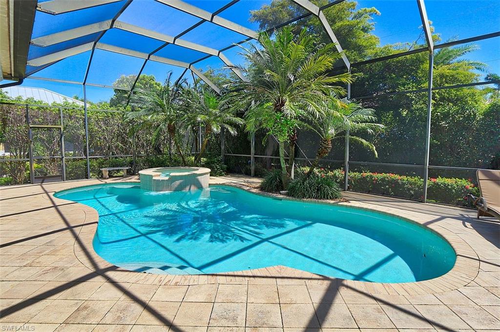 1824 Crayton Road Naples, FL 34102 - Photo 33 of 37 a view of a backyard with table and chairs under an umbrella