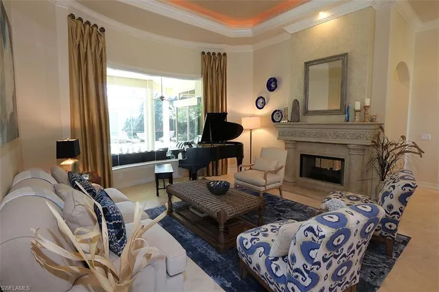 a living room with furniture fireplace and a large window