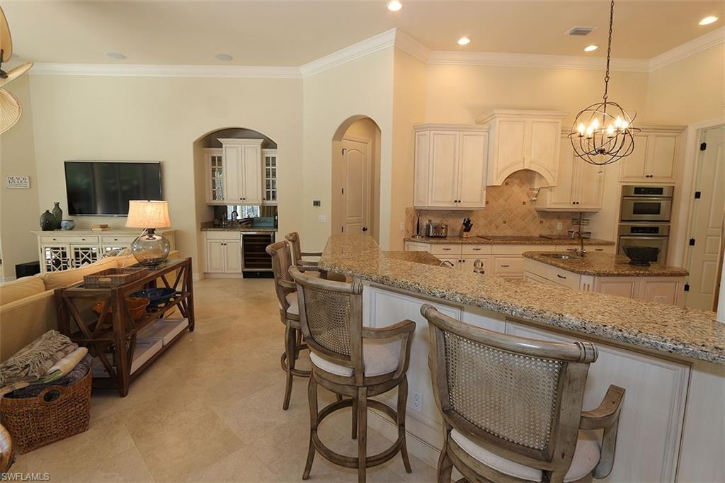 1824 Crayton Road Naples, FL 34102 - Photo 9 of 37 a large kitchen with granite countertop a stove a sink a window and chairs
