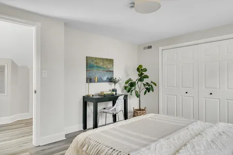 a bedroom with a bed and a potted plant