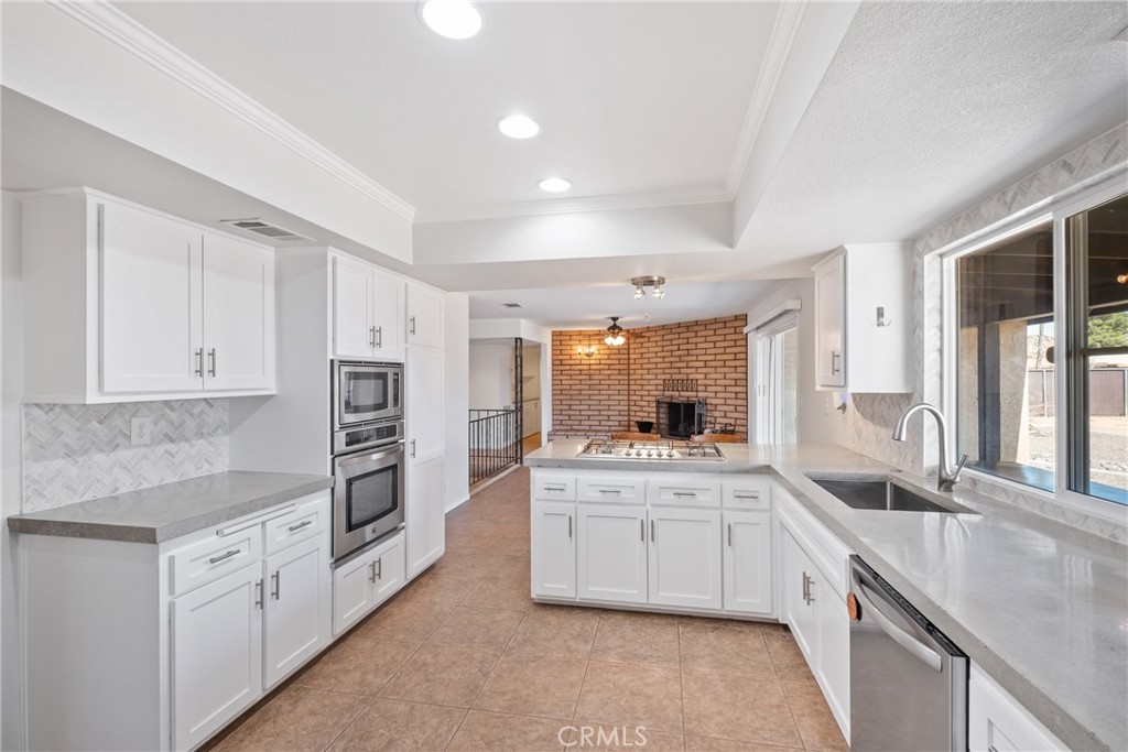 14295 Santee Road Apple Valley, CA 92307 - Photo 1 of 1 a kitchen with granite countertop a sink stove and cabinets