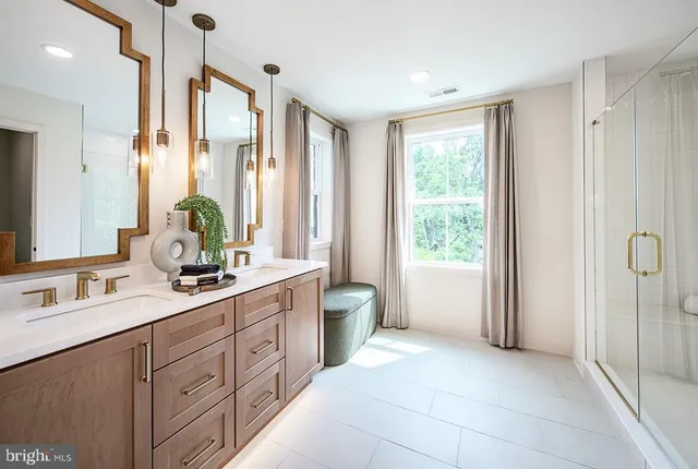 a spacious bathroom with a double vanity sink a large mirror a shower and a bathtub