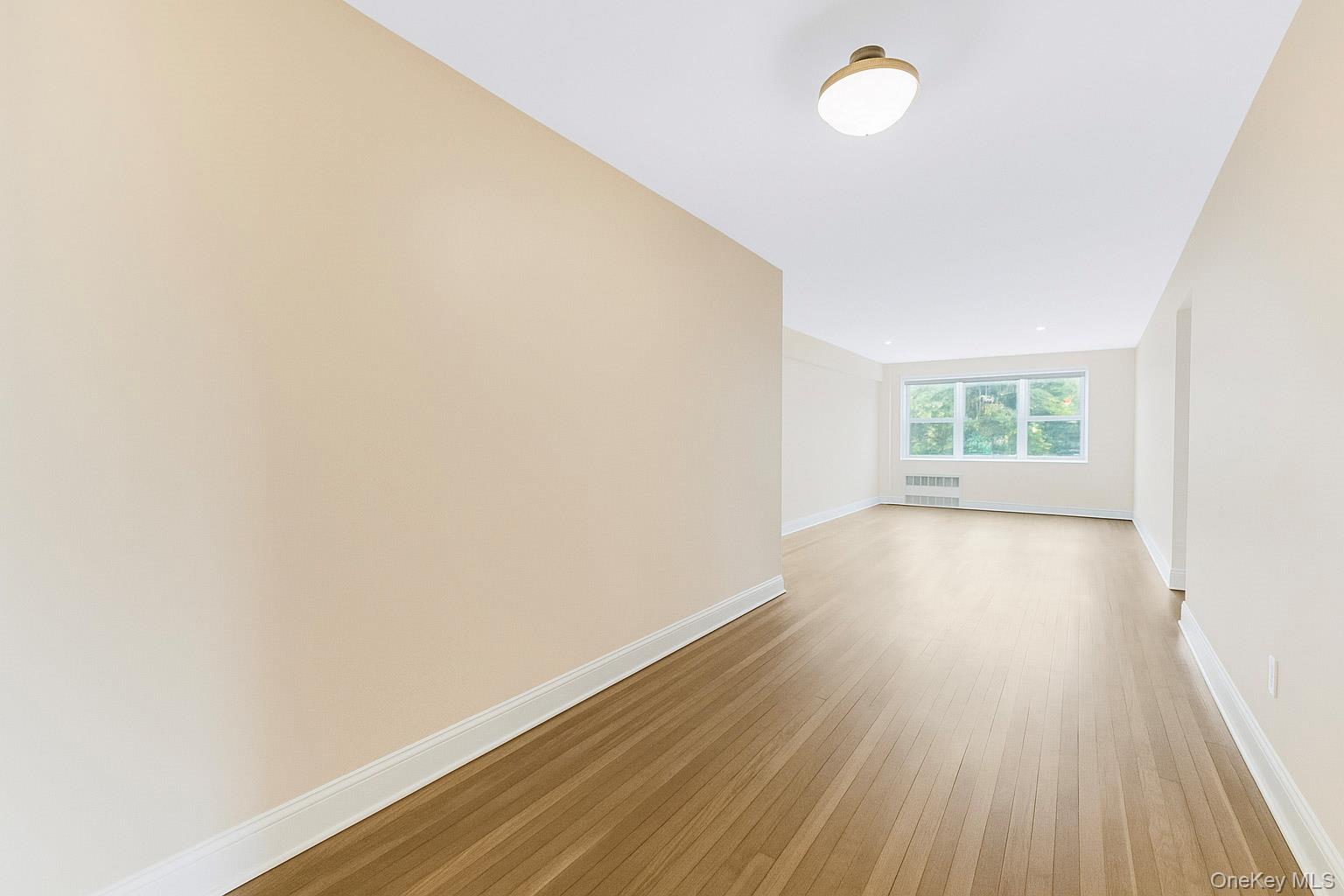 609 Palmer Road, Unit 4J Yonkers, NY 10701 - Photo 13 of 26 an empty room with wooden floor and windows