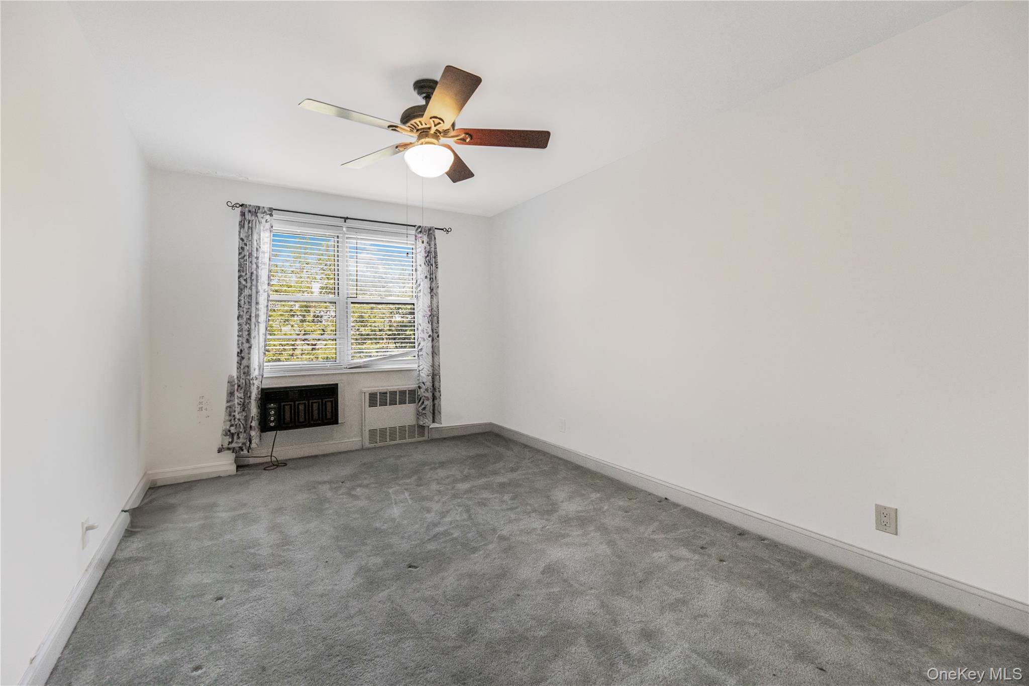 609 Palmer Road, Unit 4J Yonkers, NY 10701 - Photo 17 of 26 an empty room with windows and ceiling fan