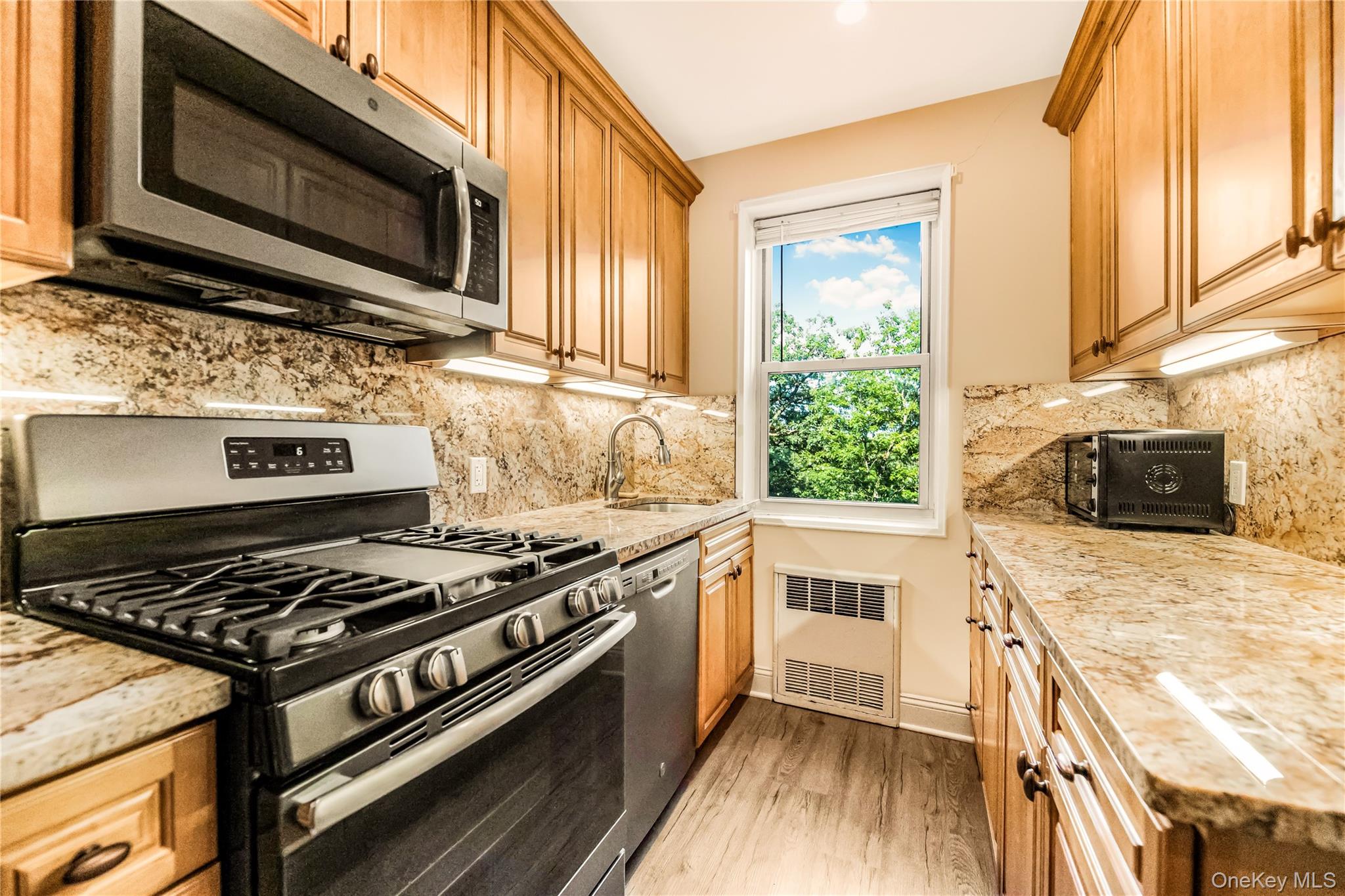 609 Palmer Road, Unit 4J Yonkers, NY 10701 - Photo 10 of 26 a kitchen with a stove a sink and a microwave