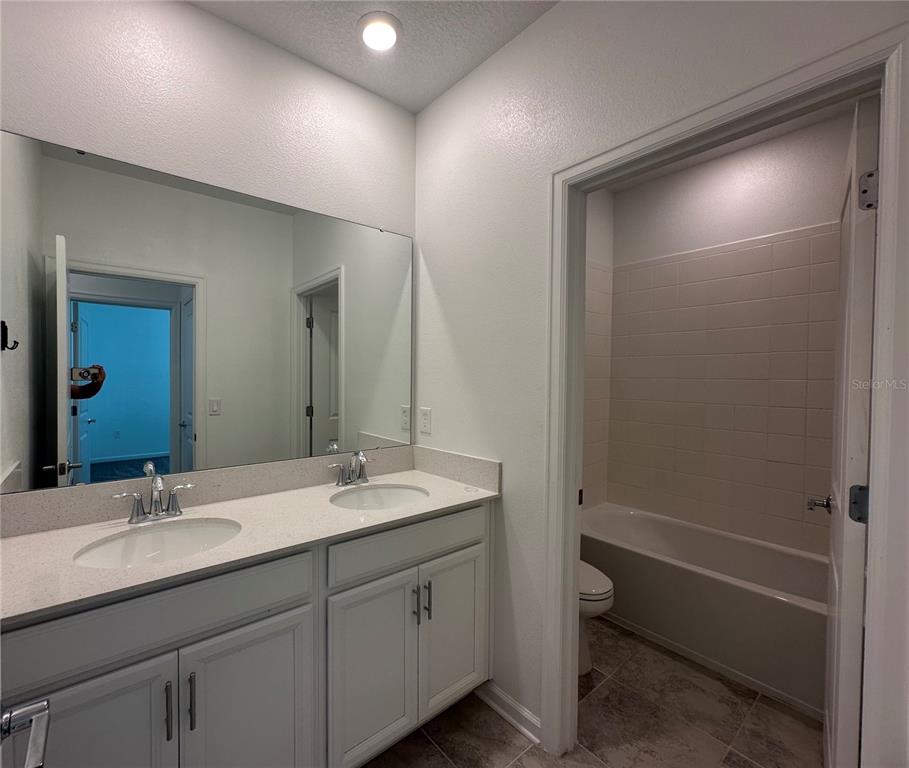 17136 Salty Dog Road Winter Garden, FL 34787 - Photo 26 of 38 a bathroom with a double vanity sink toilet mirror and bathtub