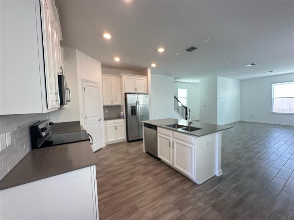 17136 Salty Dog Road Winter Garden, FL 34787 - Photo 3 of 38 a kitchen with stainless steel appliances granite countertop a sink stove and refrigerator
