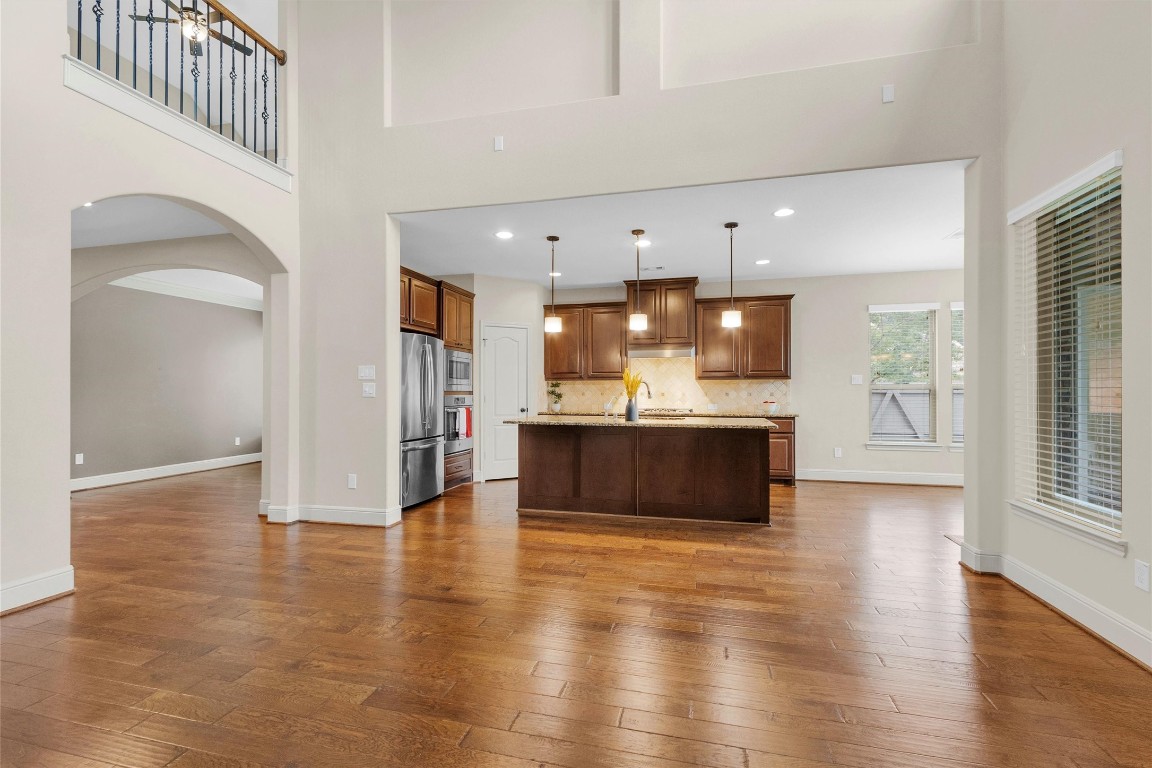 17203 Prairie Falcon Lane Conroe, TX 77385 - Photo 11 of 30 a view of a kitchen with kitchen island a sink wooden floor and a large window