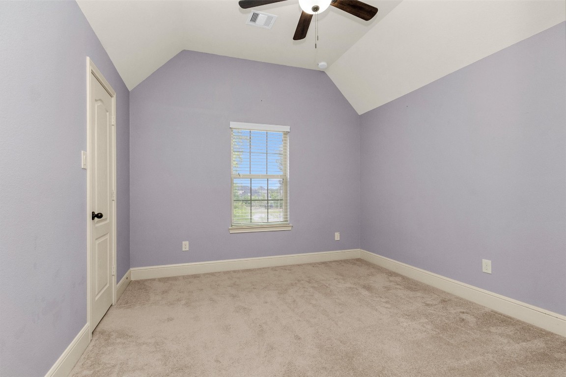17203 Prairie Falcon Lane Conroe, TX 77385 - Photo 27 of 30 an empty room with chandelier fan and windows