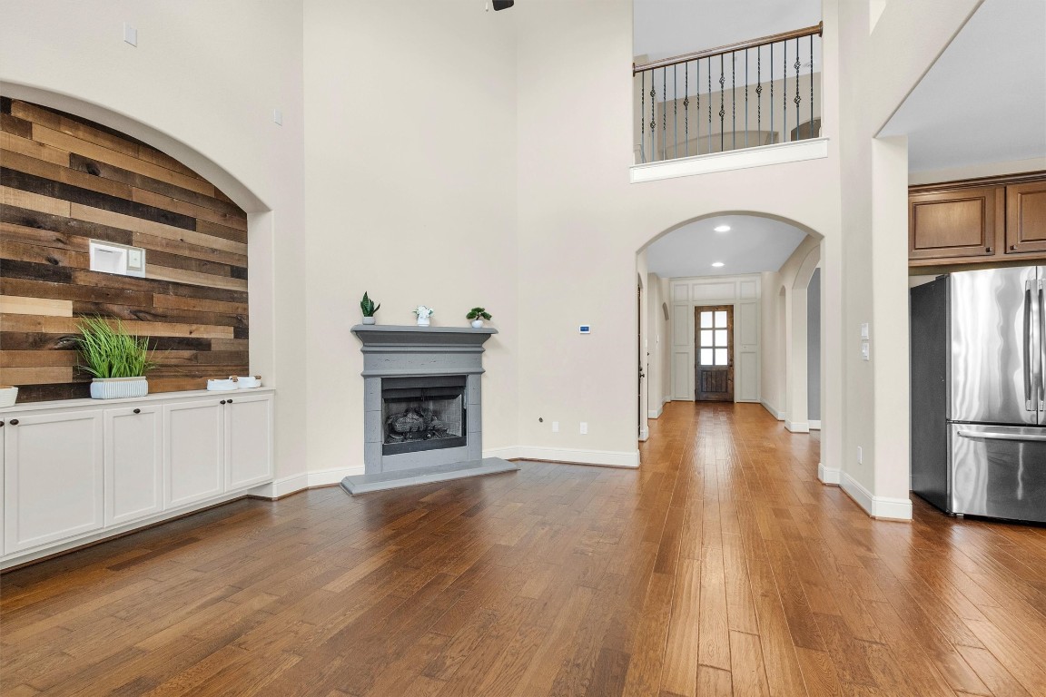 17203 Prairie Falcon Lane Conroe, TX 77385 - Photo 6 of 30 a view of a hallway with wooden floor and a fireplace