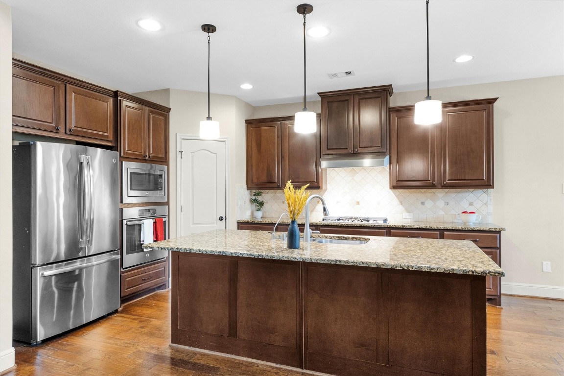 17203 Prairie Falcon Lane Conroe, TX 77385 - Photo 10 of 30 a kitchen with stainless steel appliances granite countertop a refrigerator a sink and a stove