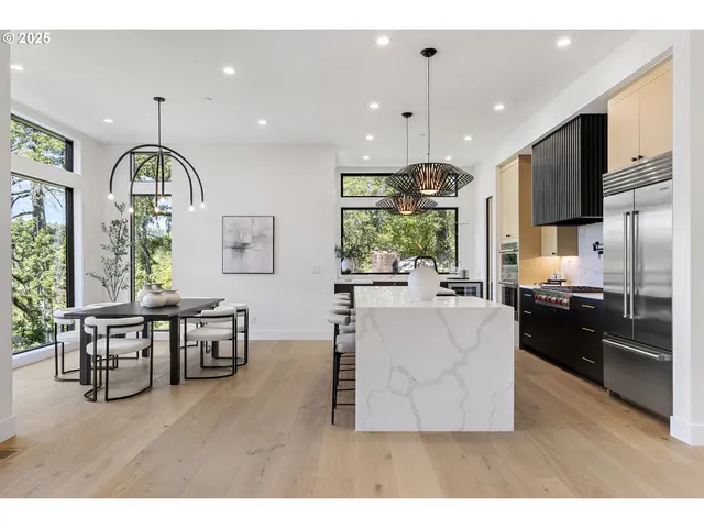 a living room with stainless steel appliances kitchen island granite countertop furniture a large window and a kitchen view