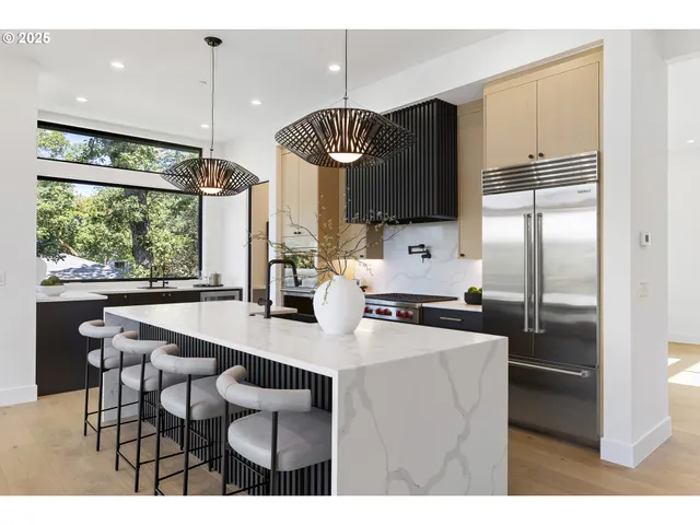 a kitchen with kitchen island a large window a sink and a refrigerator