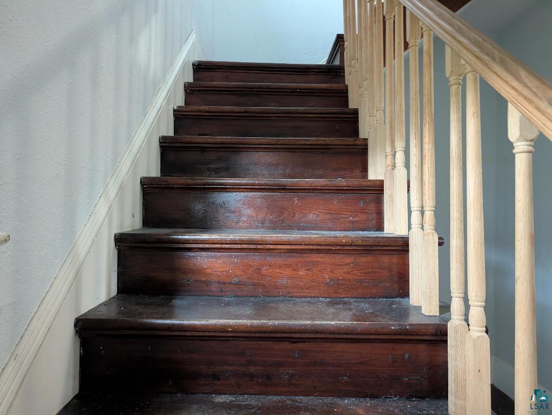 202 Thomas Street Mellen, WI 54546 - Photo 19 of 37 Wood-finish staircase with light-toned balusters and handrail