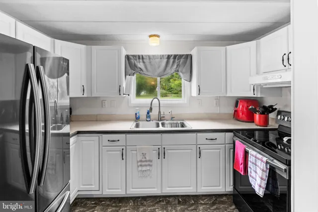 a kitchen with granite countertop a sink stainless steel appliances and cabinets