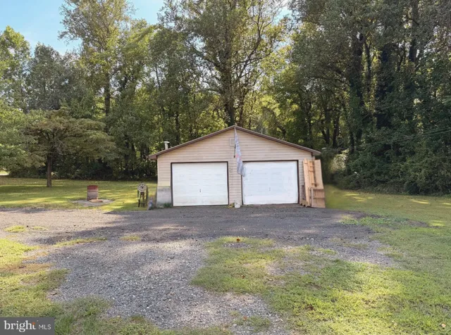 a view of a house with a yard and large tree