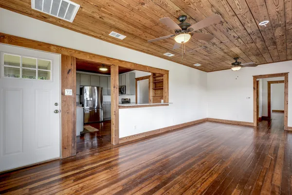 a view of empty room with wooden floor