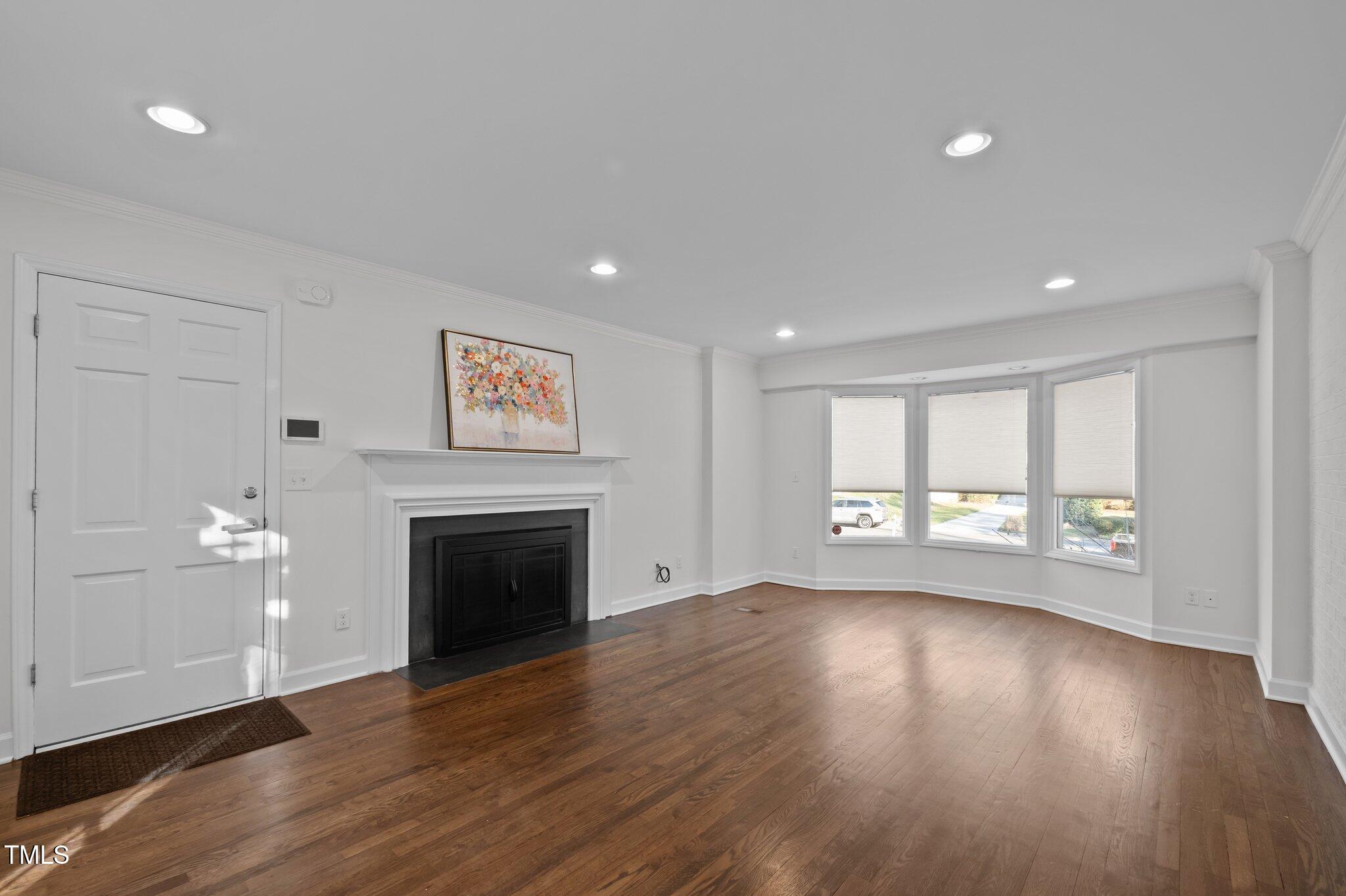 3930 St Marks Road Durham, NC 27707 - Photo 17 of 41 an empty room with wooden floor fireplace and windows