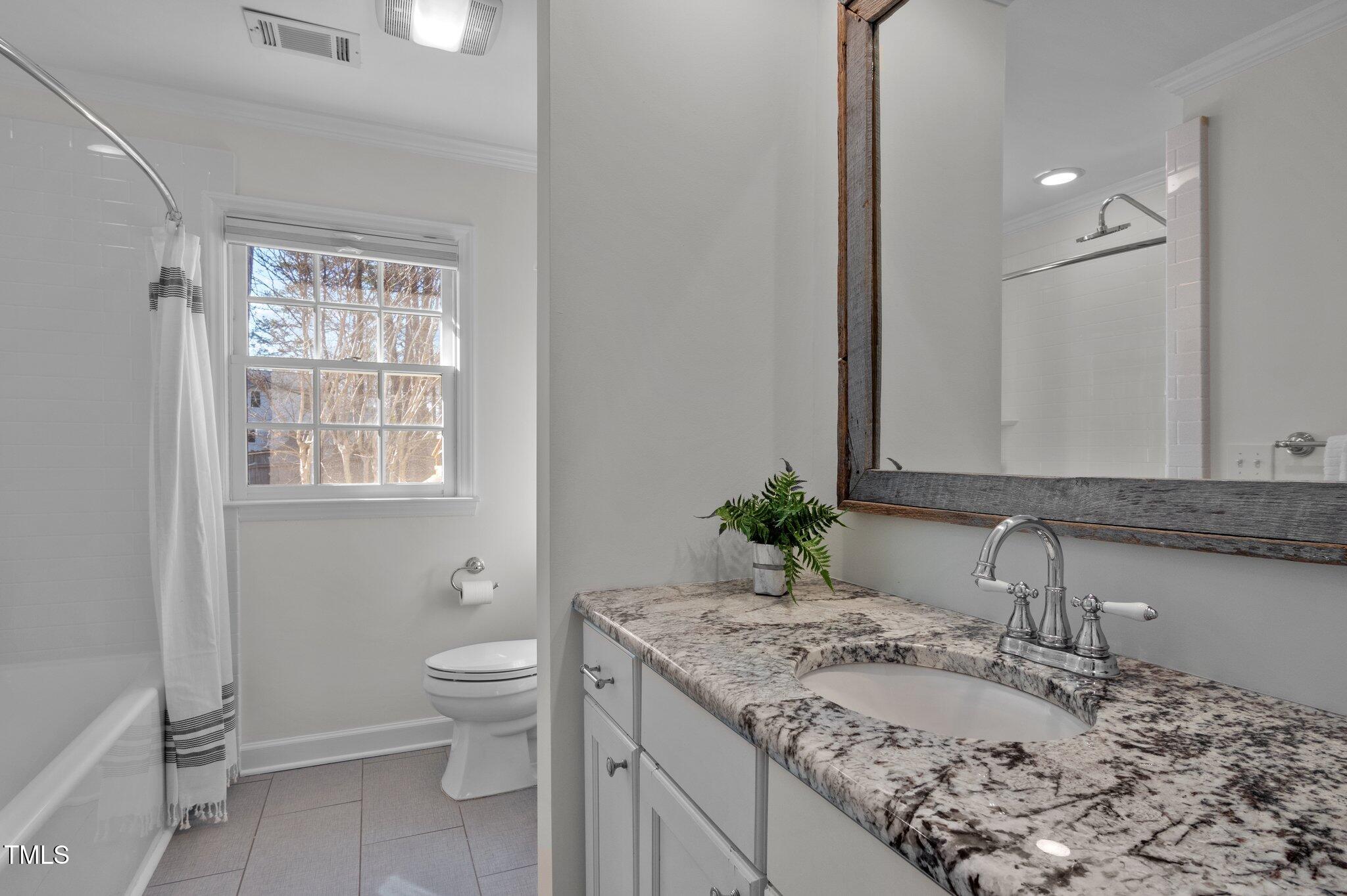 3930 St Marks Road Durham, NC 27707 - Photo 28 of 41 a bathroom with a granite countertop sink toilet and mirror