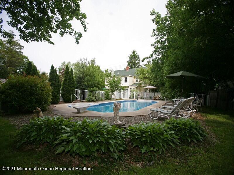 34 Rumson Road Little Silver, NJ 07739 - Photo 20 of 29 a view of a swimming pool with lawn chairs under an umbrella