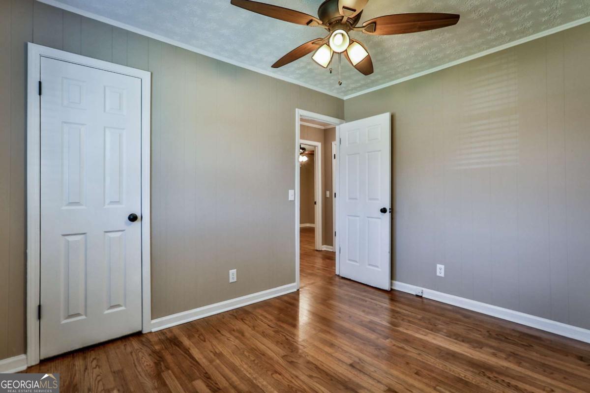 680 North Avenue Madison, GA 30650 - Photo 19 of 20 wooden floor in an empty room with a chandelier fan