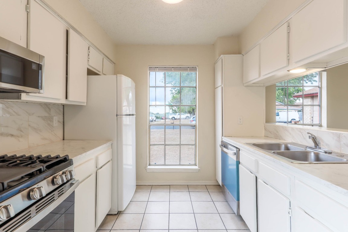 1915 Prairie Knoll Court, Unit B Austin, TX 78758 - Photo 4 of 15 a kitchen with a stove a sink and a refrigerator