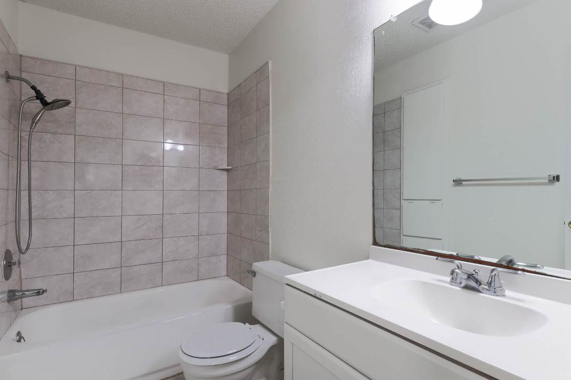 1915 Prairie Knoll Court, Unit B Austin, TX 78758 - Photo 8 of 15 a bathroom with a sink a toilet and shower
