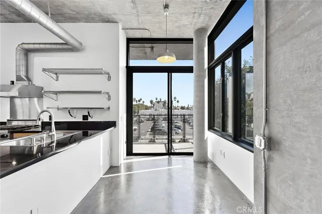 a view of a kitchen with a sink and refrigerator