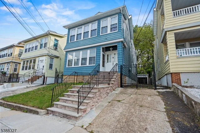 front view of a residential apartment building with a yard