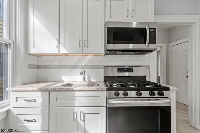 a kitchen with microwave a stove and cabinets