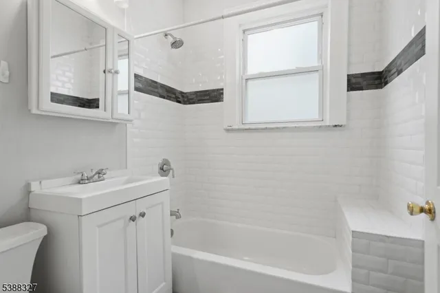 a bathroom with a sink a mirror toilet and bathtub