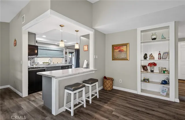 a kitchen with granite countertop cabinets and wooden floor