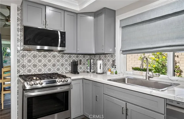 a kitchen with stainless steel appliances a stove a microwave a sink and cabinets